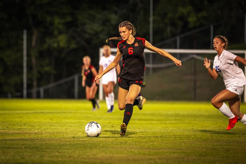 A soccer player kicks the ball